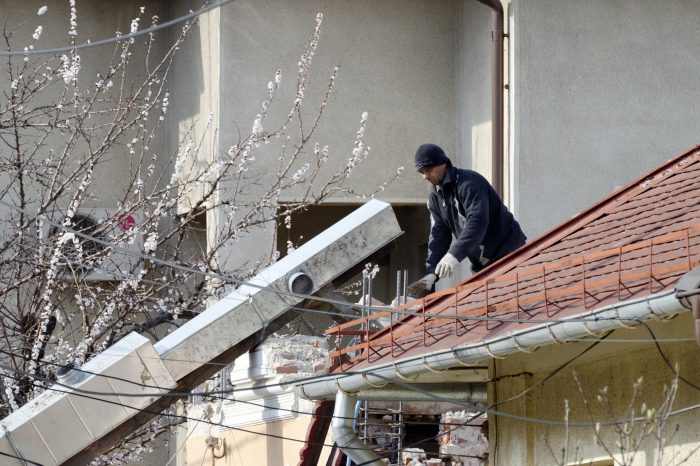 A man repairing the roof of a home