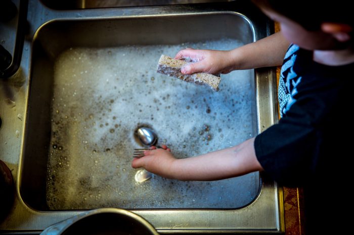 A boy cleaning a sink